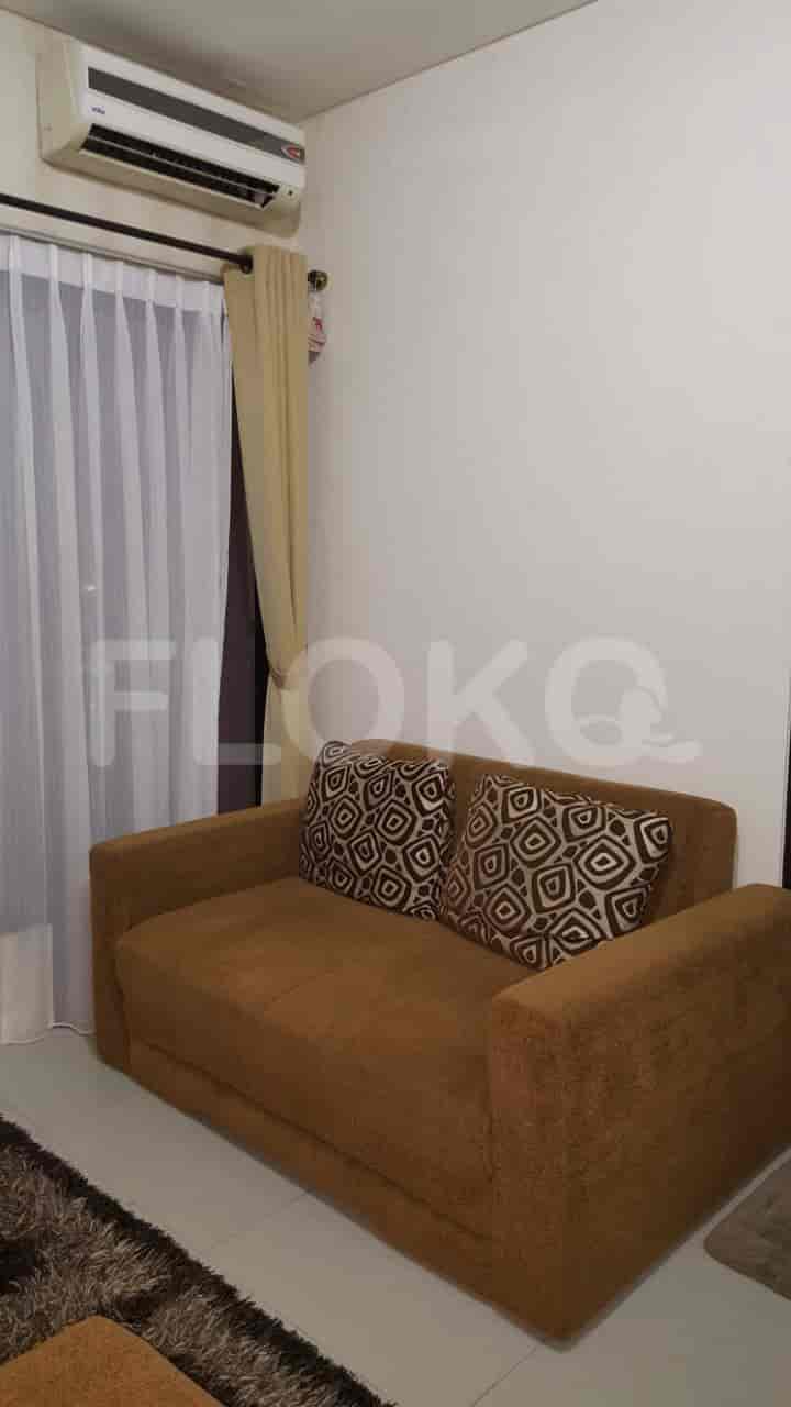 A living room with a brown sofa, pillows, and an air conditioner.