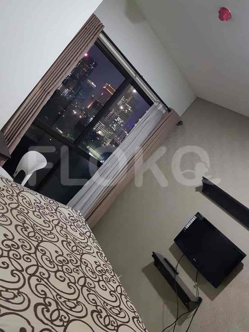 A cozy bedroom with a bed, city view, and window curtains.