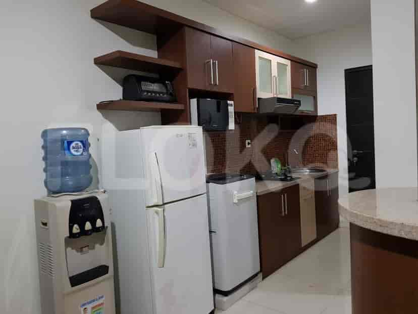 A well-equipped kitchen with wooden cabinetry, appliances, and a water dispenser.