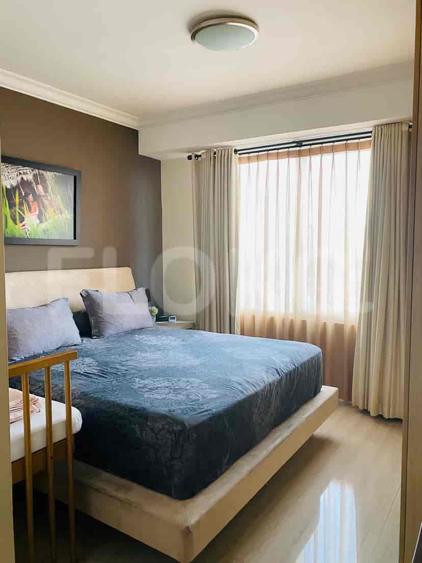 Kamar tidur dengan tempat tidur ukuran king, meja samping tempat tidur, dan gorden.