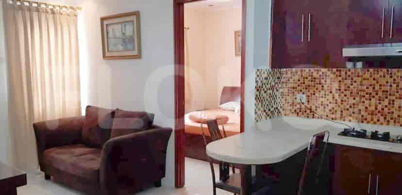A view of the living room with a glimpse of the kitchen.