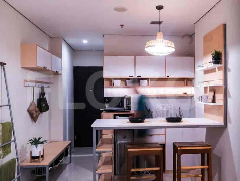 A small apartment kitchen with a breakfast bar and a minimalist entryway with a towel rack.