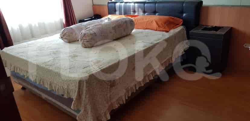 Bedroom with a bed with floral sheets and large pillows.
