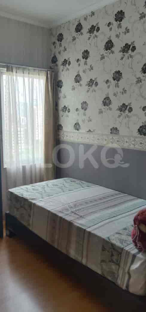 A bedroom featuring a single bed, floral wallpaper, and a window with sheer curtains.