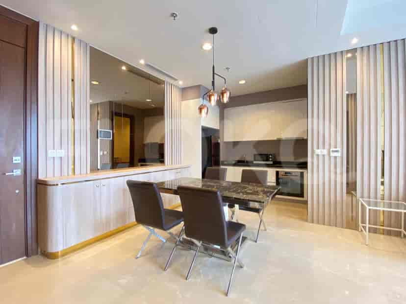A modern dining area with a dark marble dining table, and decorative light fixtures.