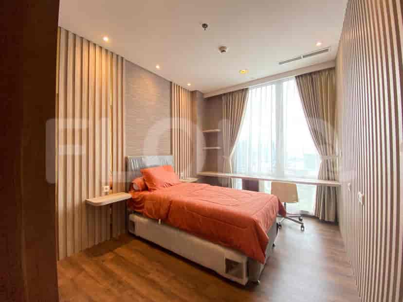 A cozy bedroom featuring a bed with a vibrant orange duvet and wooden flooring.