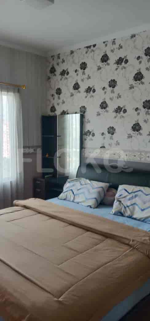 A master bedroom featuring a bed, wallpaper, and a mirror.