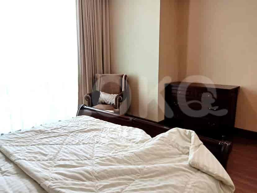 Cozy bedroom with a large bed, a dresser, and a reading chair, featuring a warm and inviting atmosphere.