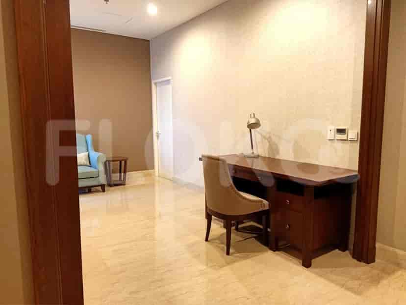 A well-lit study room with a desk, chair, and additional seating area, showcasing a modern interior design.