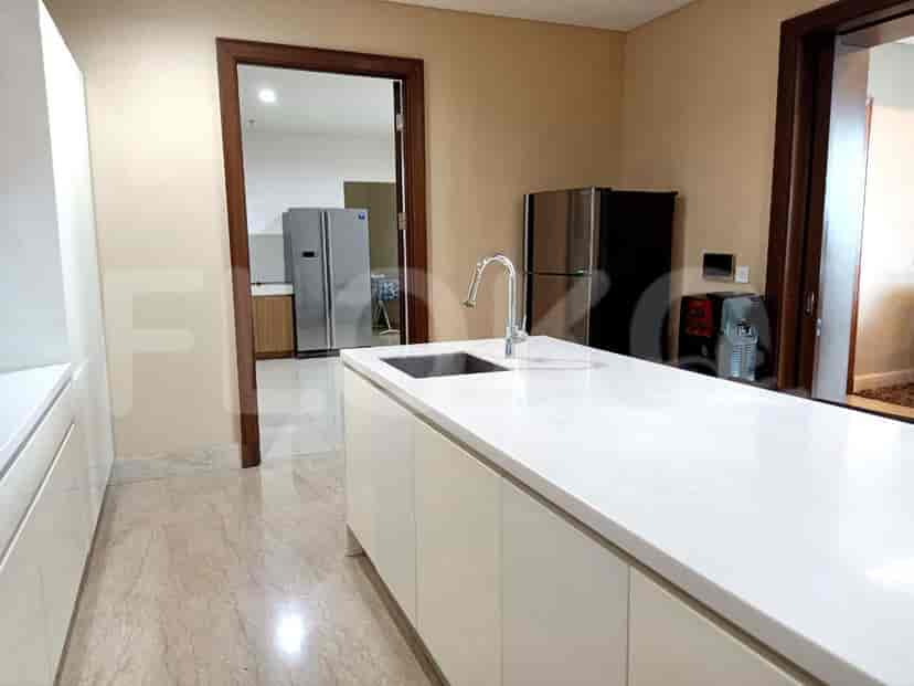 A well-equipped kitchen with a white island, modern appliances, and a view into the other rooms.