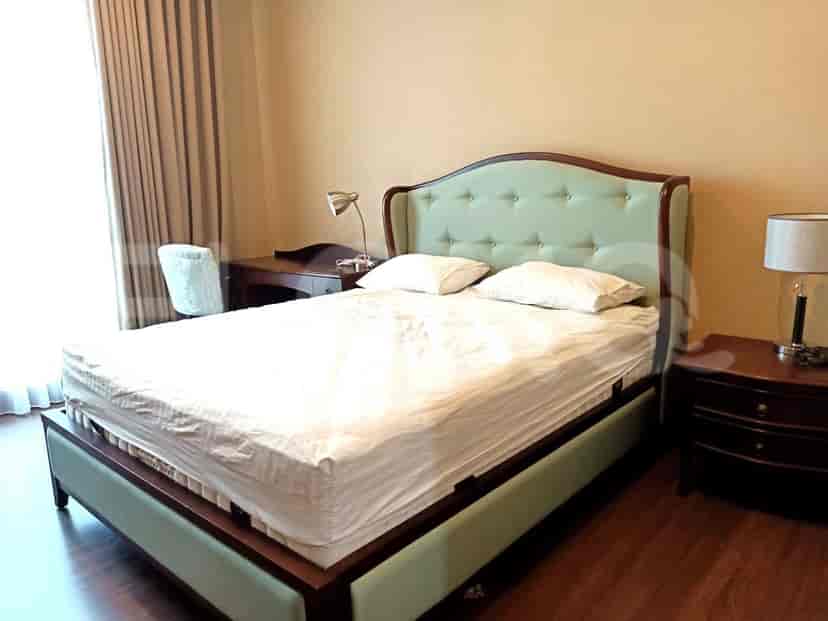 A spacious bedroom with a bed, a desk, and a reading chair, featuring a stylish and modern interior design.
