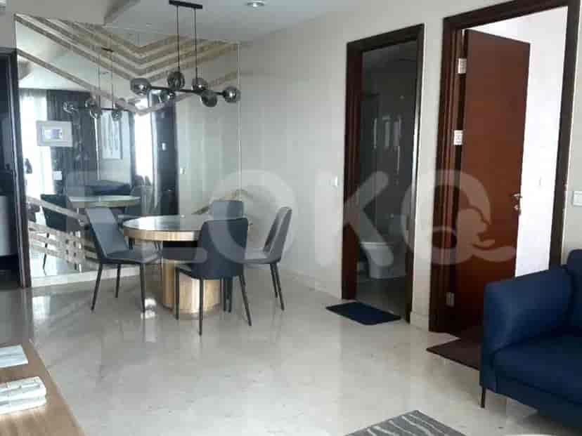 Area ruang tamu dan makan modern dengan meja bundar, kursi bergaya, dan akses ke kamar mandi.