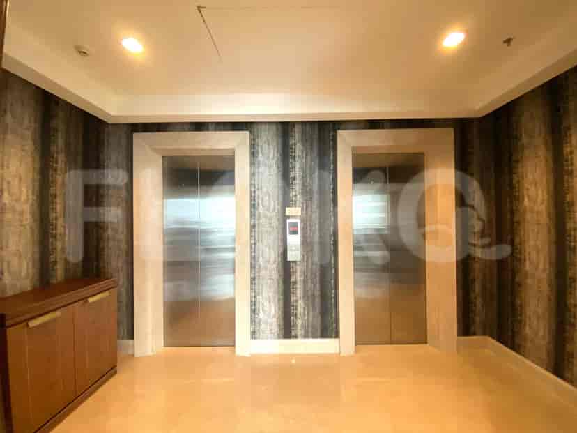 A hallway with two elevators and a storage cabinet.