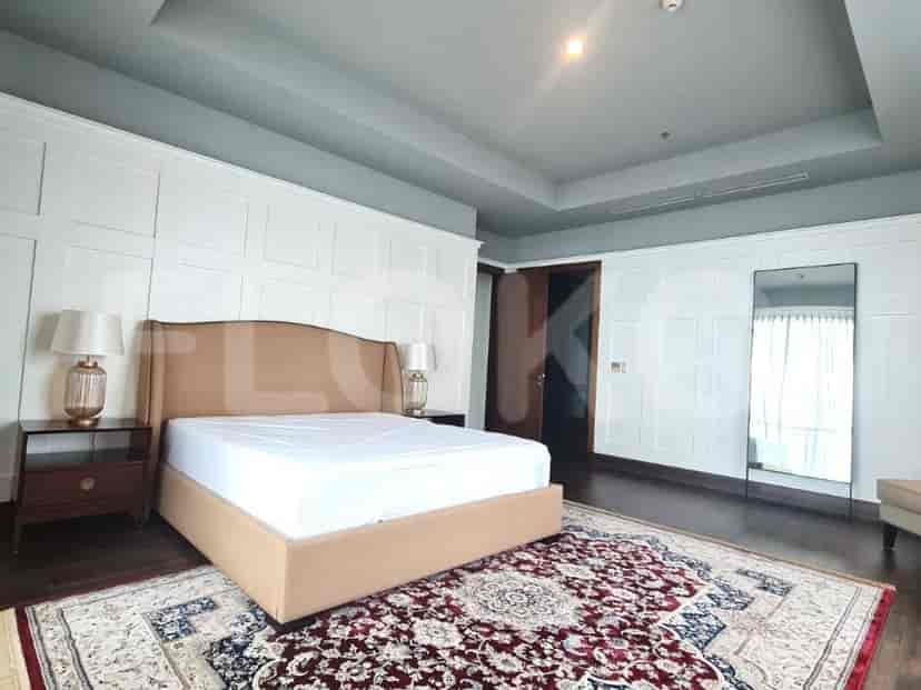 A bedroom with a bed, bedside tables, and lamps.