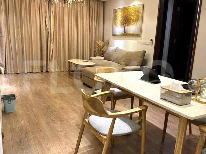 Modern living and dining area with wooden flooring, a sectional sofa, and a dining table with chairs.