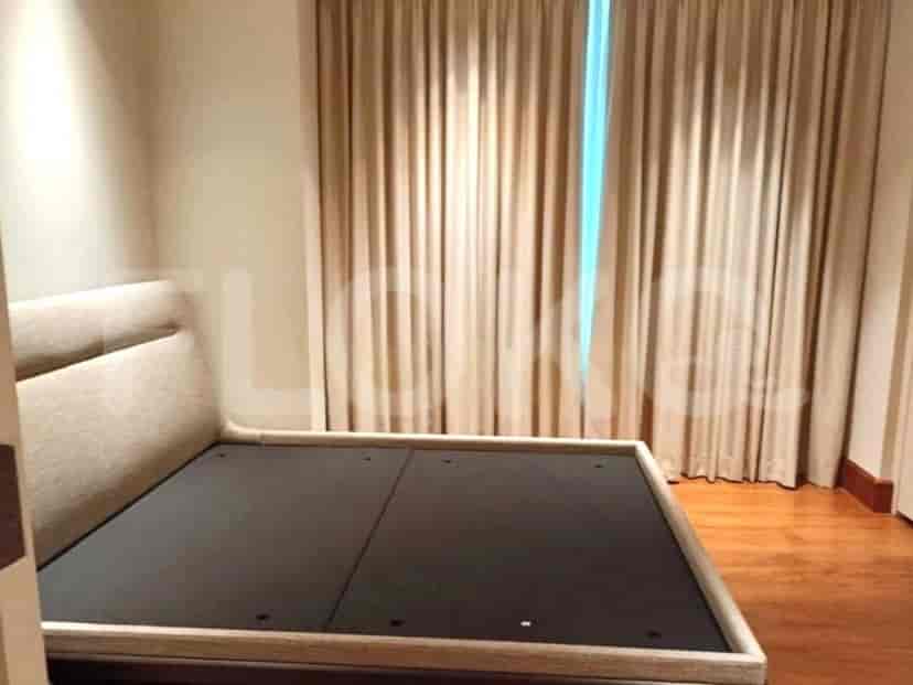 A closer view of the bed without bedding, in the bedroom.