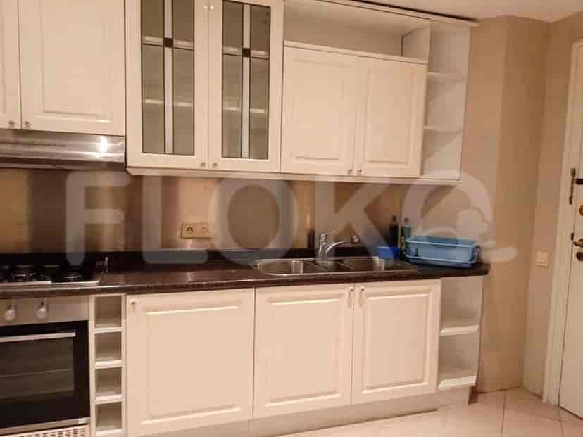 A white kitchen with cabinets, a double sink, and an oven.