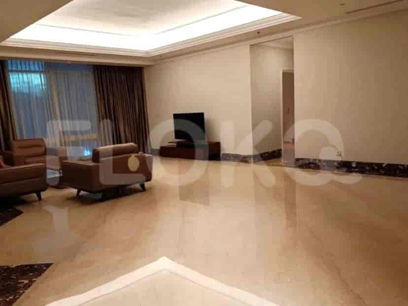 Spacious living area with marble flooring, a TV on a wooden stand, and large windows.