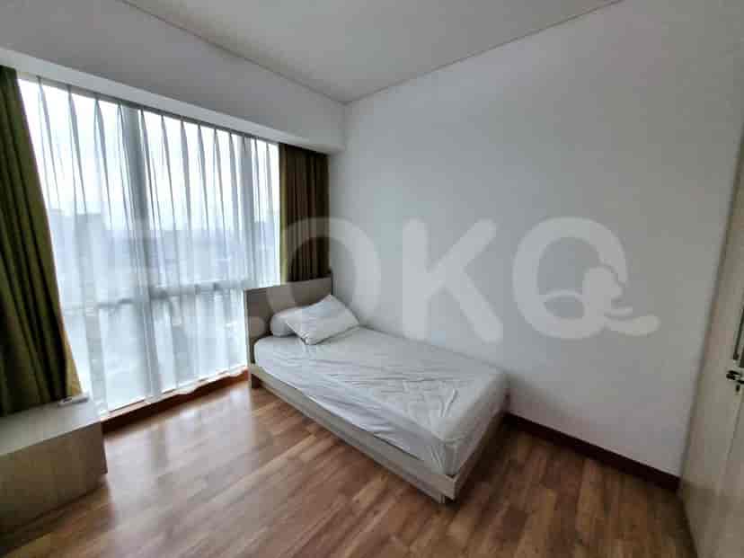 A compact bedroom with a single bed and large windows.