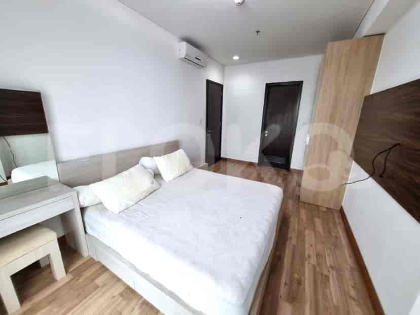 A master bedroom with a large bed, vanity, and closet.