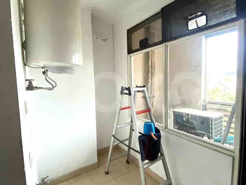A utility room with a water heater and ladder.