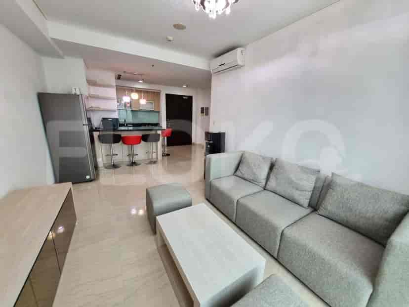 Modern apartment featuring an open-plan living area with a grey sofa, combined with a stylish kitchen.