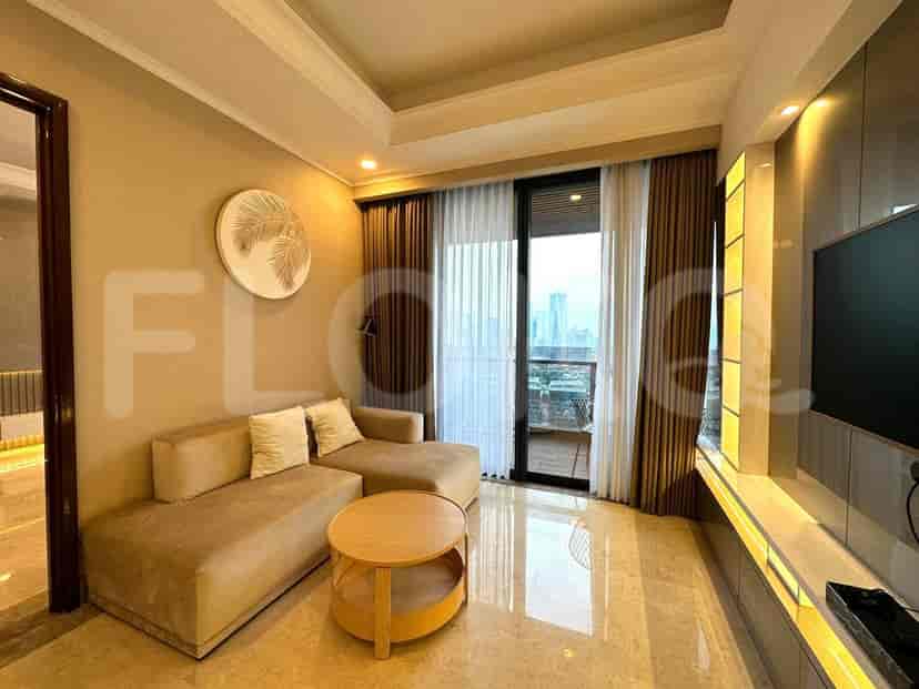 The living room showing the sofa, wall-mounted TV, and balcony.