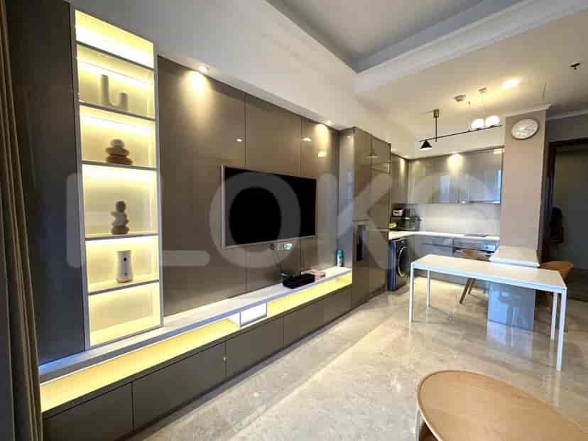 Combined living and kitchen area, with a TV, built-in cabinets, and kitchen setup visible.