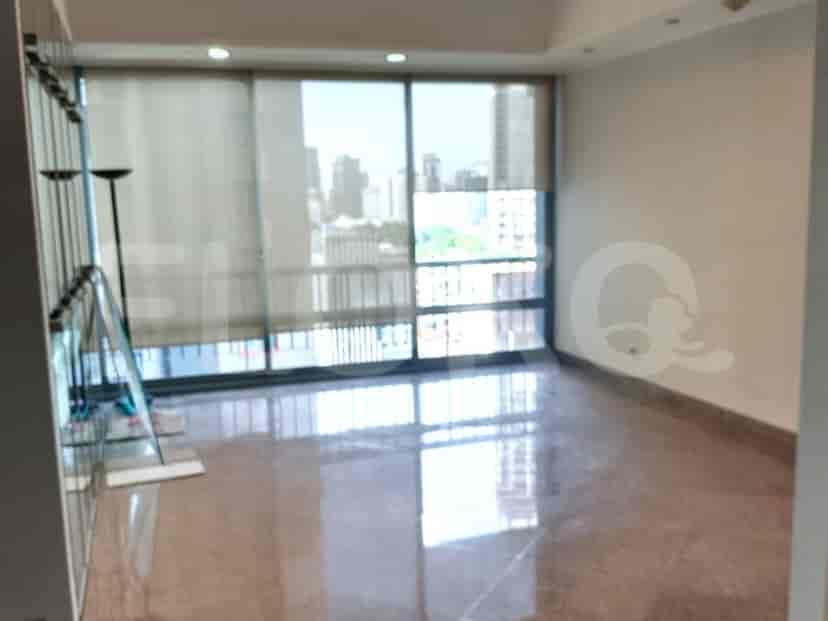 Empty living room with large windows and marble flooring.