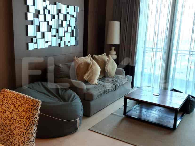Ruang tamu modern dengan sofa abu-abu, bean bag, dan seni dinding cermin.