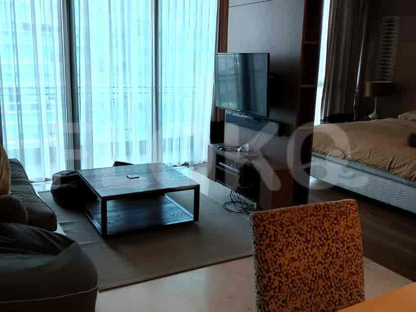 Ruang tamu dengan sofa, meja kopi, dan jendela besar dengan gorden.