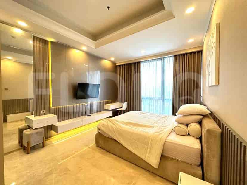 A master bedroom with a large bed, wall-mounted TV, and custom wall features.