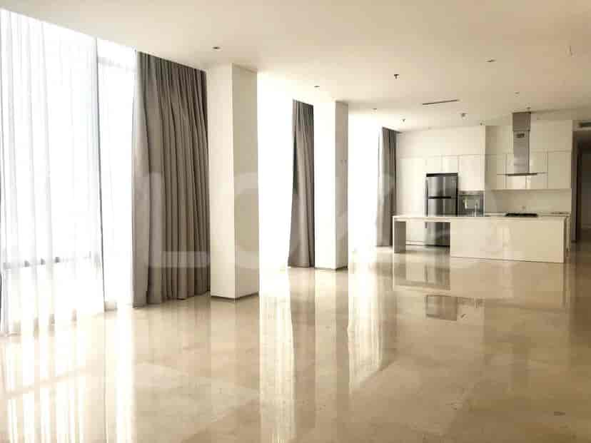 Open-plan living and kitchen area with marble flooring, white cabinets, and a stainless steel refrigerator.