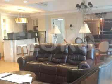 Spacious living room with a dark brown leather sofa, and a kitchen area with a breakfast bar.