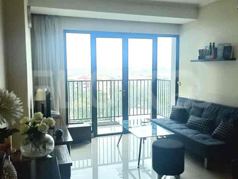 A well-lit living room with a view, featuring a modern sofa and glass coffee table.