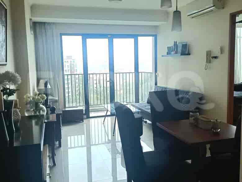 Combined living and dining area with a dining table, chairs, and access to a balcony.