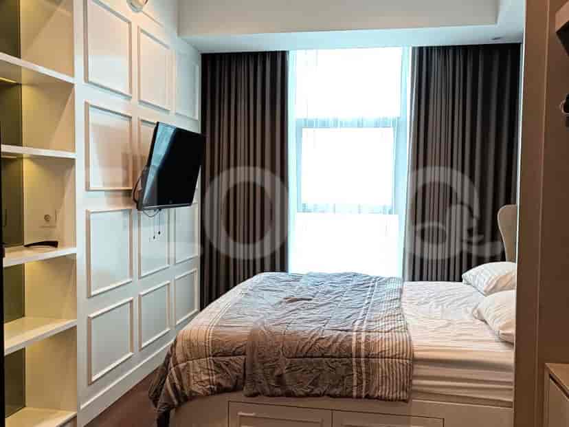 Kamar tidur dengan tempat tidur, TV, dan rak built-in.