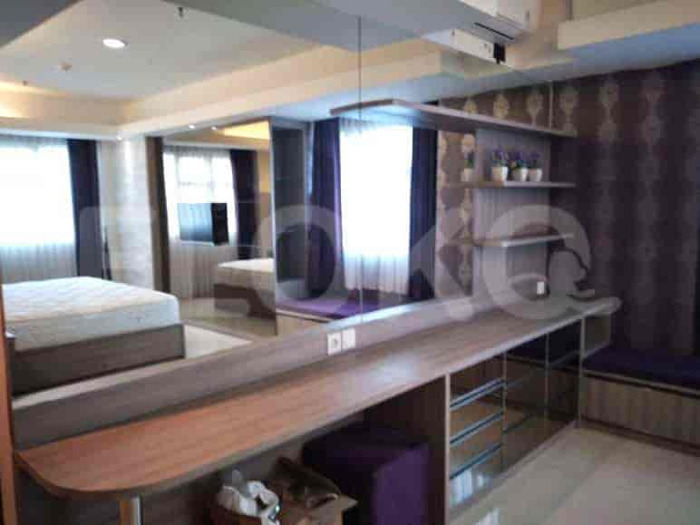 A bedroom with a bed, built-in desk, and ample closet space.