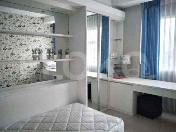 A modern bedroom with a double bed, a built-in desk, and ample closet space.