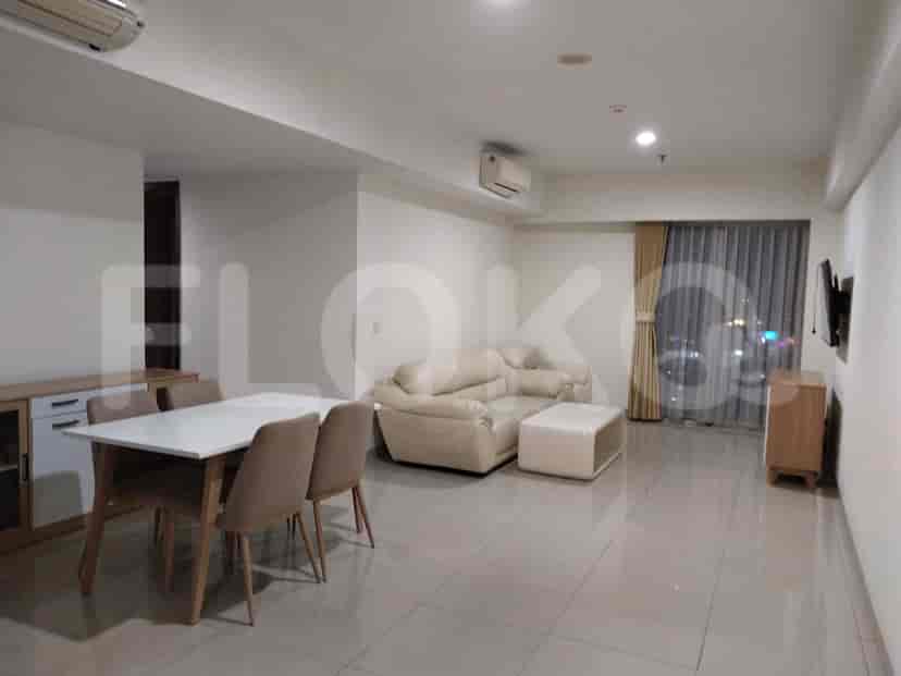 Living room with a cream sofa, dining table, and a cabinet.