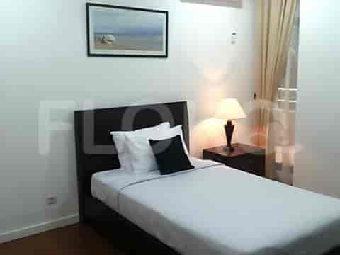 A bedroom with a single bed, bedside table, and artwork.