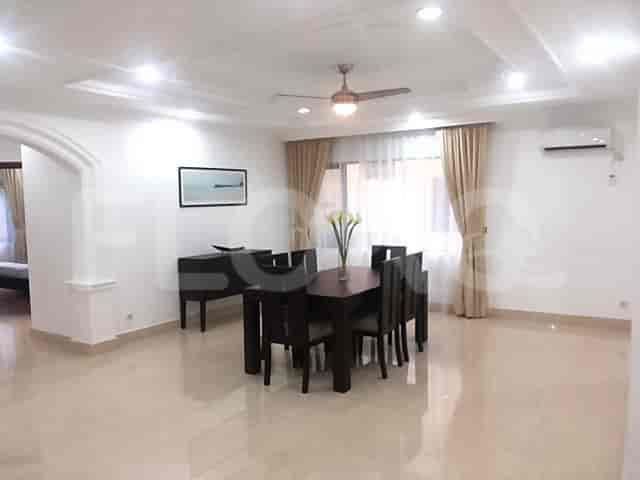 A dining area features a dark wood table with six chairs and a cabinet.