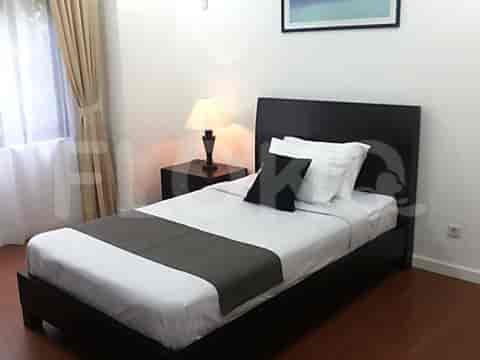 A bedroom with a single bed, bedside table and artwork.