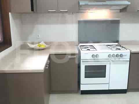 A kitchen with a gas stove, cabinets, and countertops.