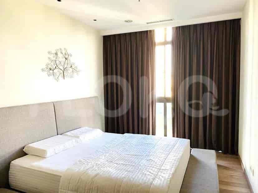 Bedroom featuring a large bed, curtains, and a wall-mounted decorative piece.