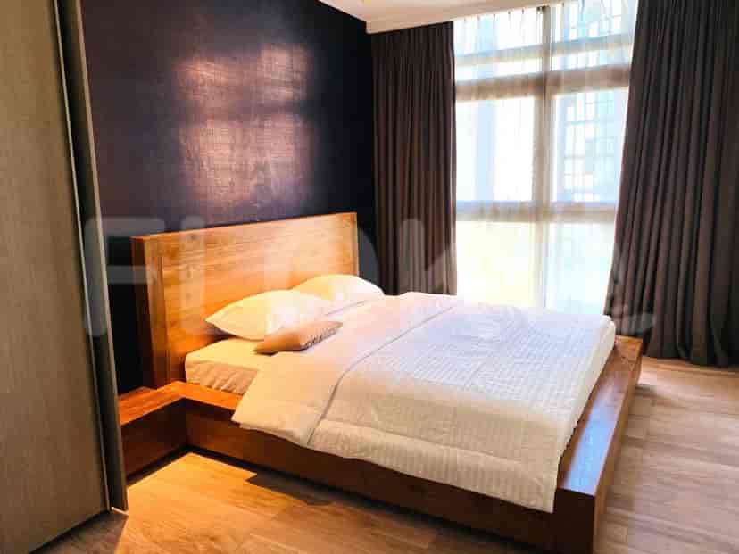 Bedroom with wooden bed frame, white bedding, and dark accent wall.
