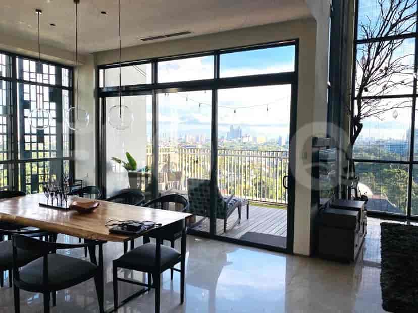 Dining area with a large dining table, chairs, and balcony access.