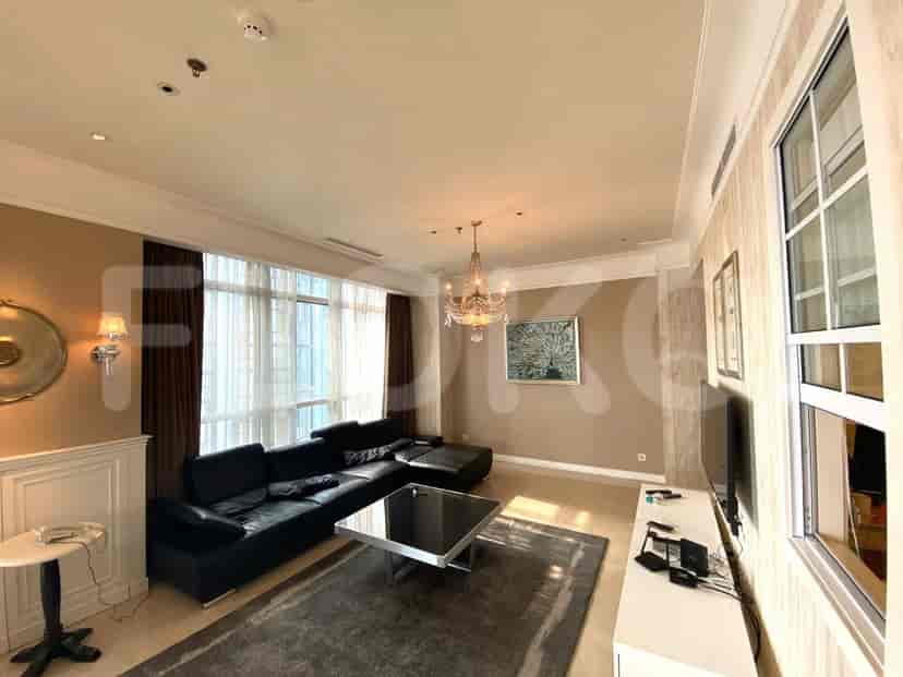 Luxurious living room with black leather sofa, glass coffee table, and chandelier.