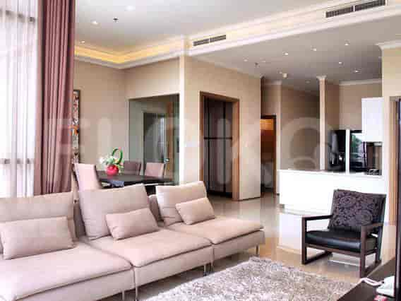 Spacious living room with an L-shaped grey sofa, large windows, and a dining area.
