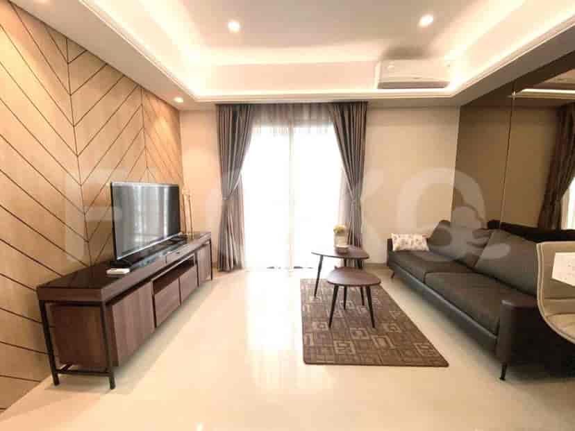 Modern living room with a wooden accent wall, TV console, and large windows.